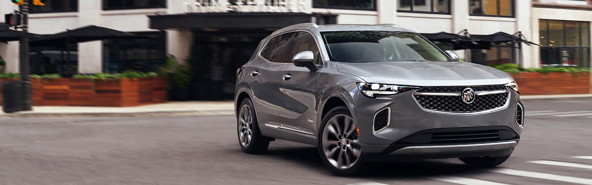 A silver buick driving though town