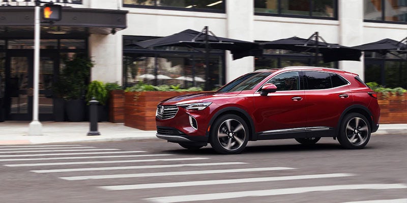 A dark red Buick driving though the city