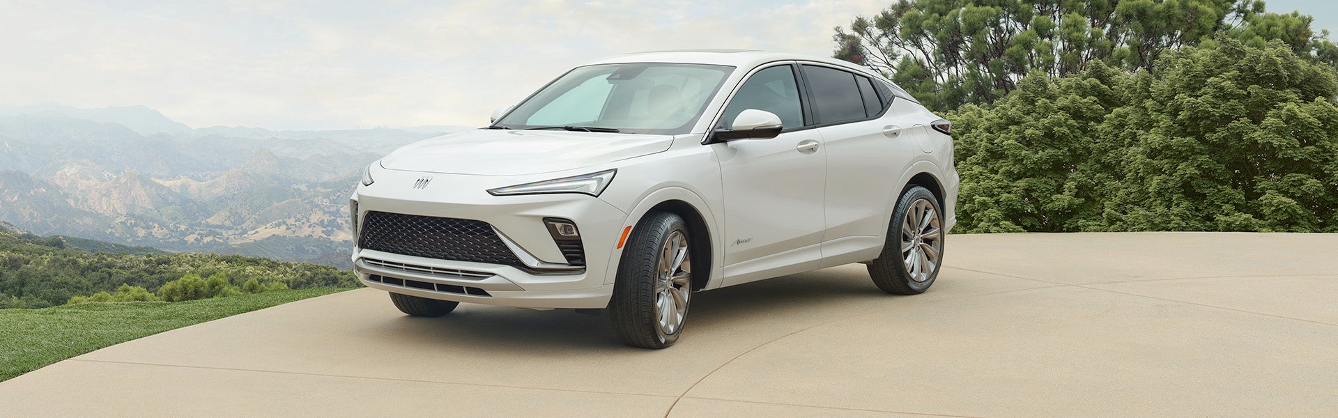 A white Buick Envista parked in the mountains