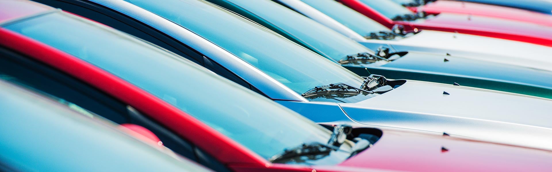 A line of cars on a lot at a dealership